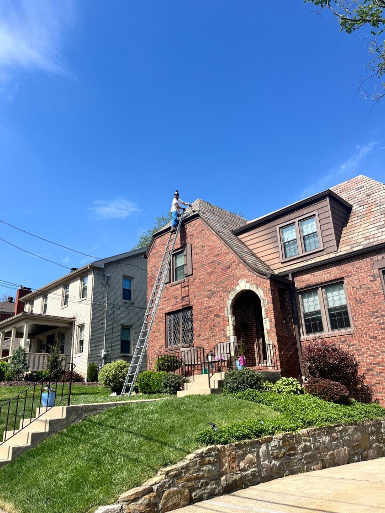 Roofer working on brick Tudor home Sharon PA — TriState Home Consulting Group